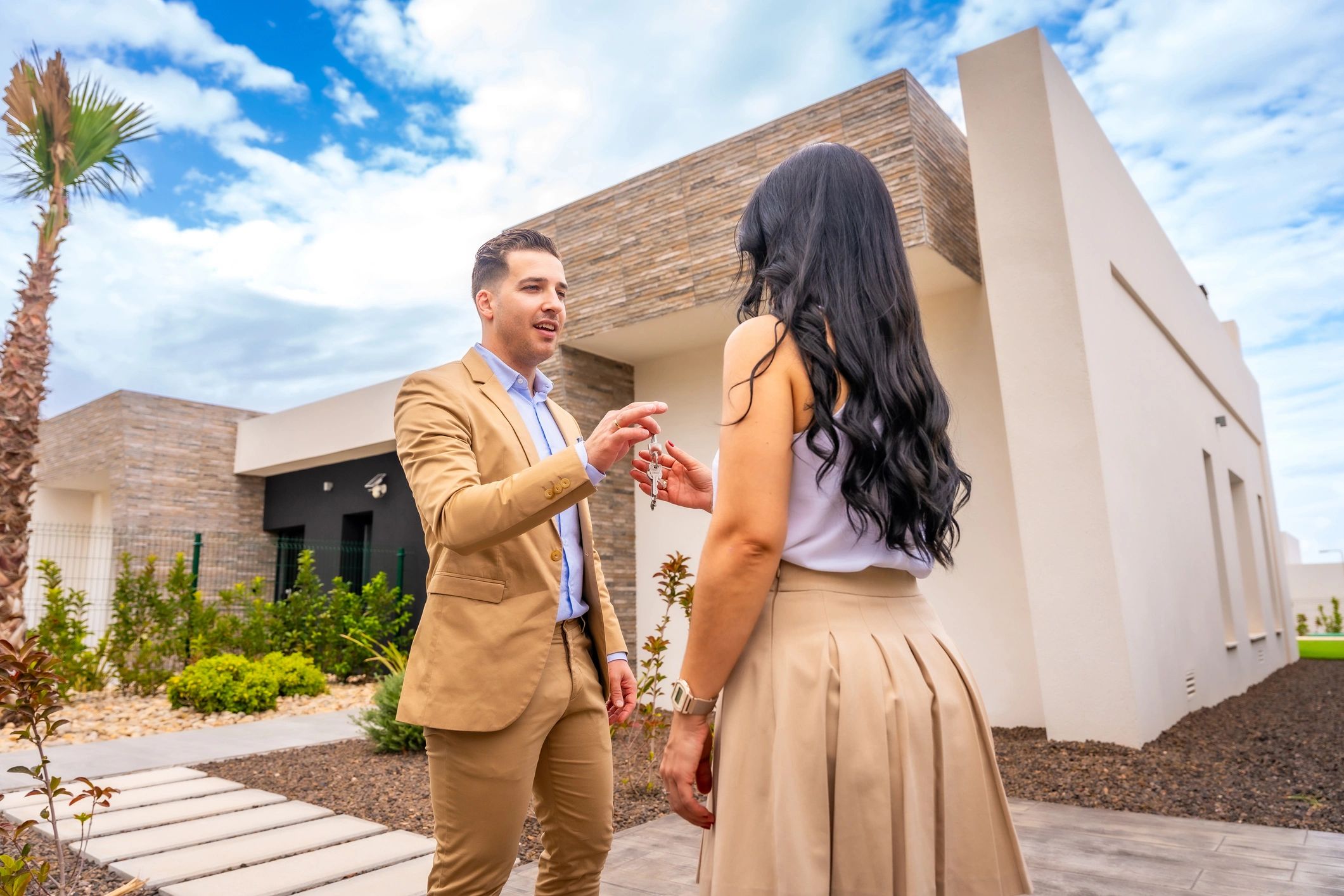 New homeowner receiving keys outside a home